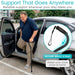 Man using a cane with a secure wrist strap attached, standing next to a car.