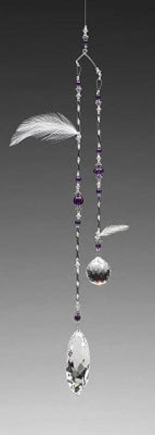 Decorative hanging mobile with crystals, feathers, and beads on a gray background