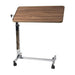 Wooden overbed table with adjustable height on a white background