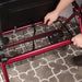 Person using a red walker with a basket on a patterned carpet