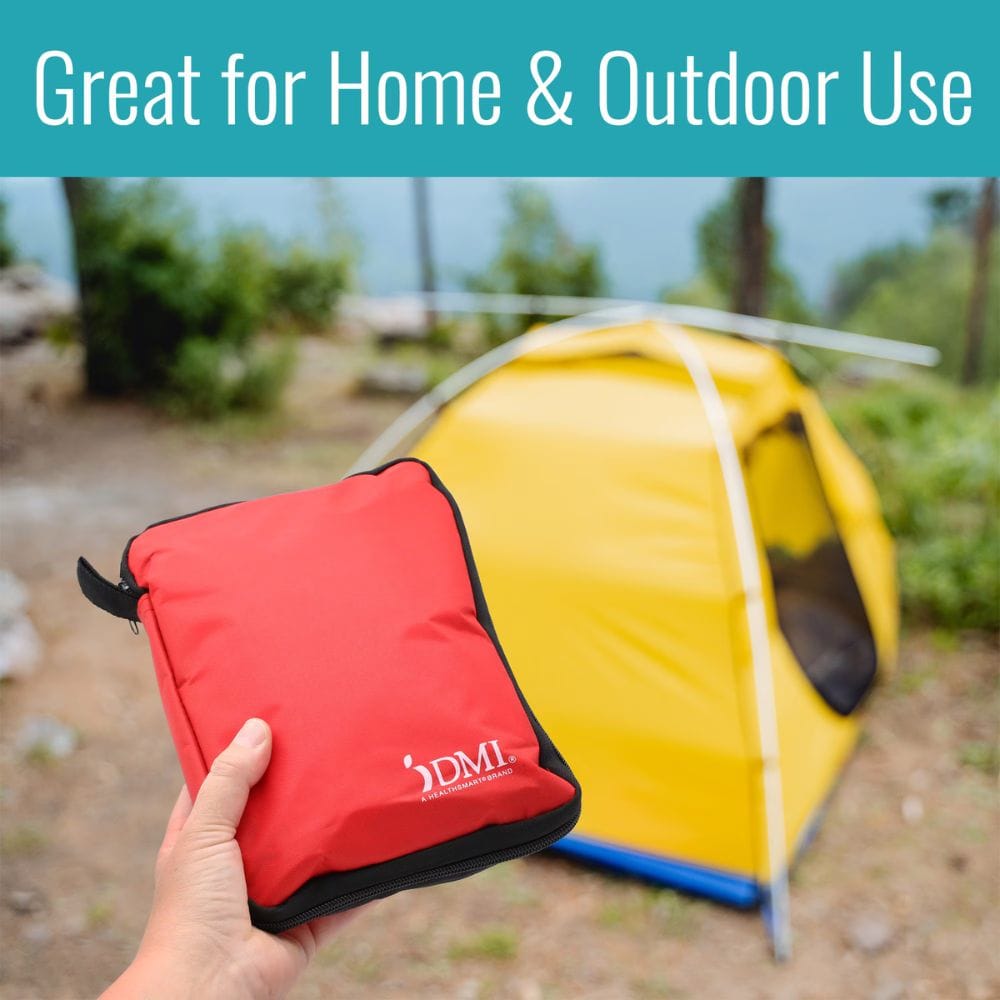 Red pouch with a logo held in front of a yellow tent outdoors.