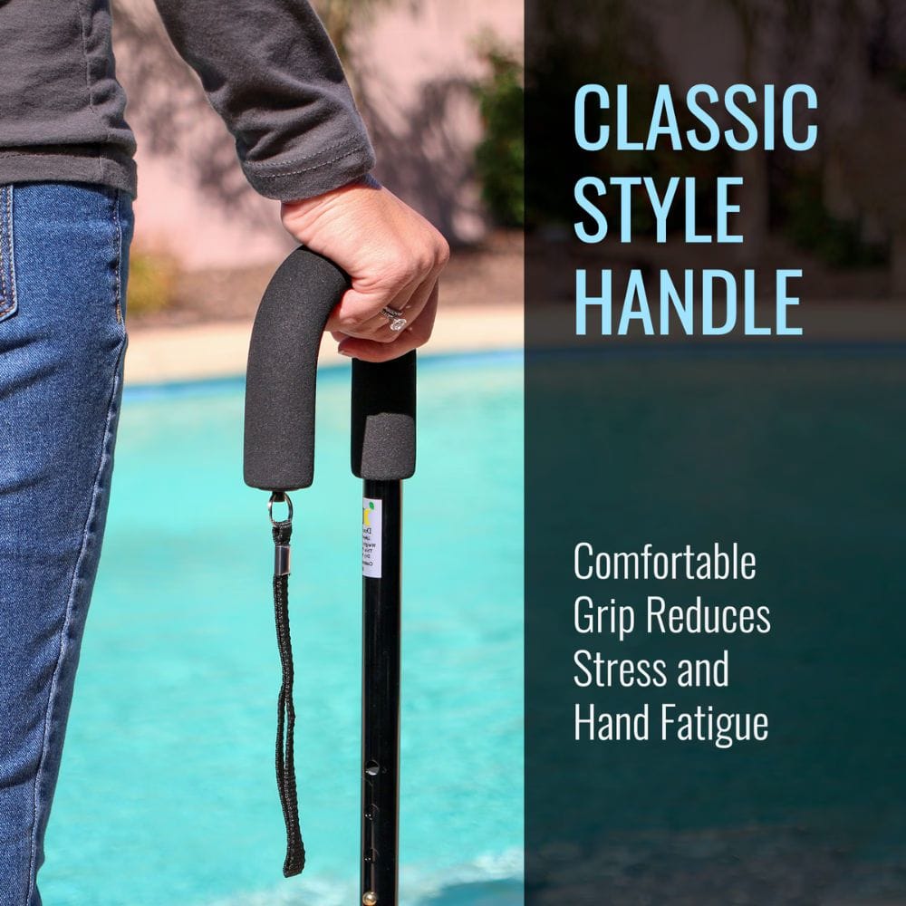 Person holding a walking cane with a classic style handle by a pool.