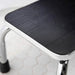 Step stool with black textured top and metal legs on a light background