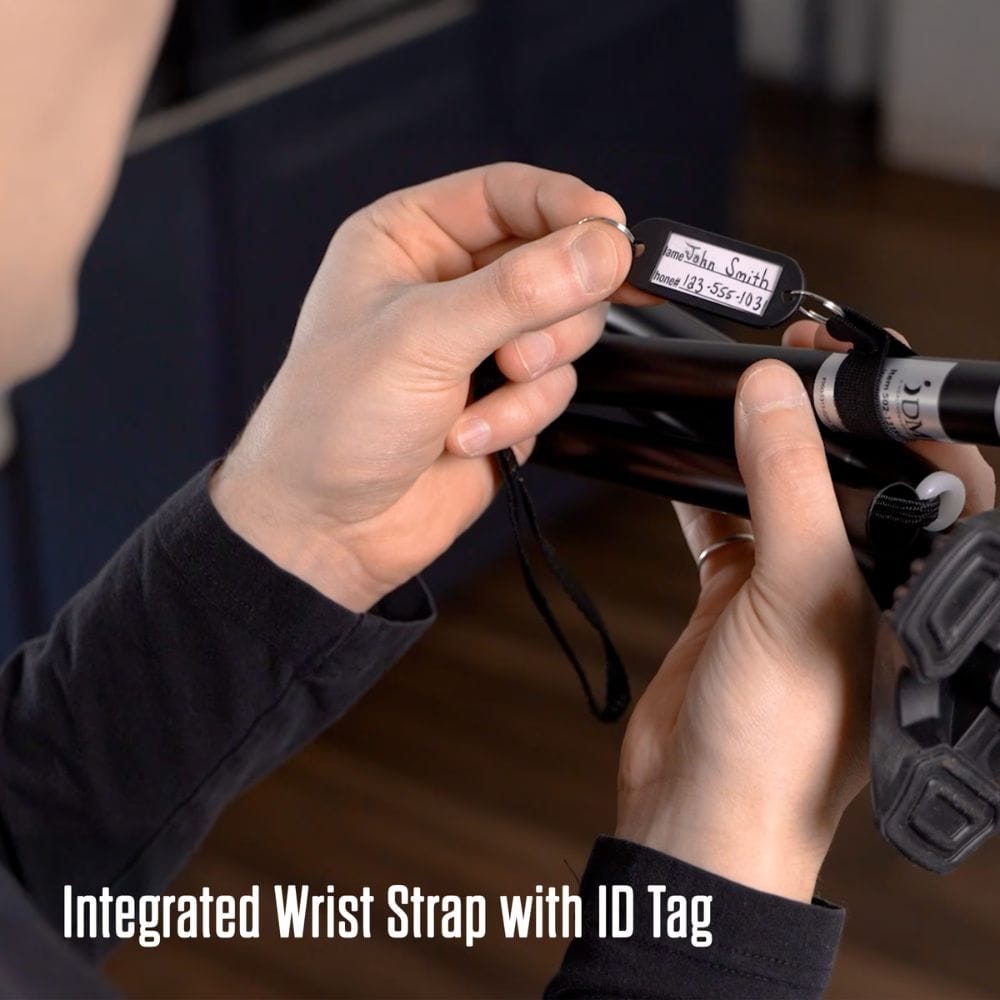 Person holding a camera with an integrated wrist strap and ID tag, with text 'Integrated Wrist Strap with ID Tag'.