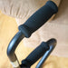 Close-up of black handles with foam grips on a beige background