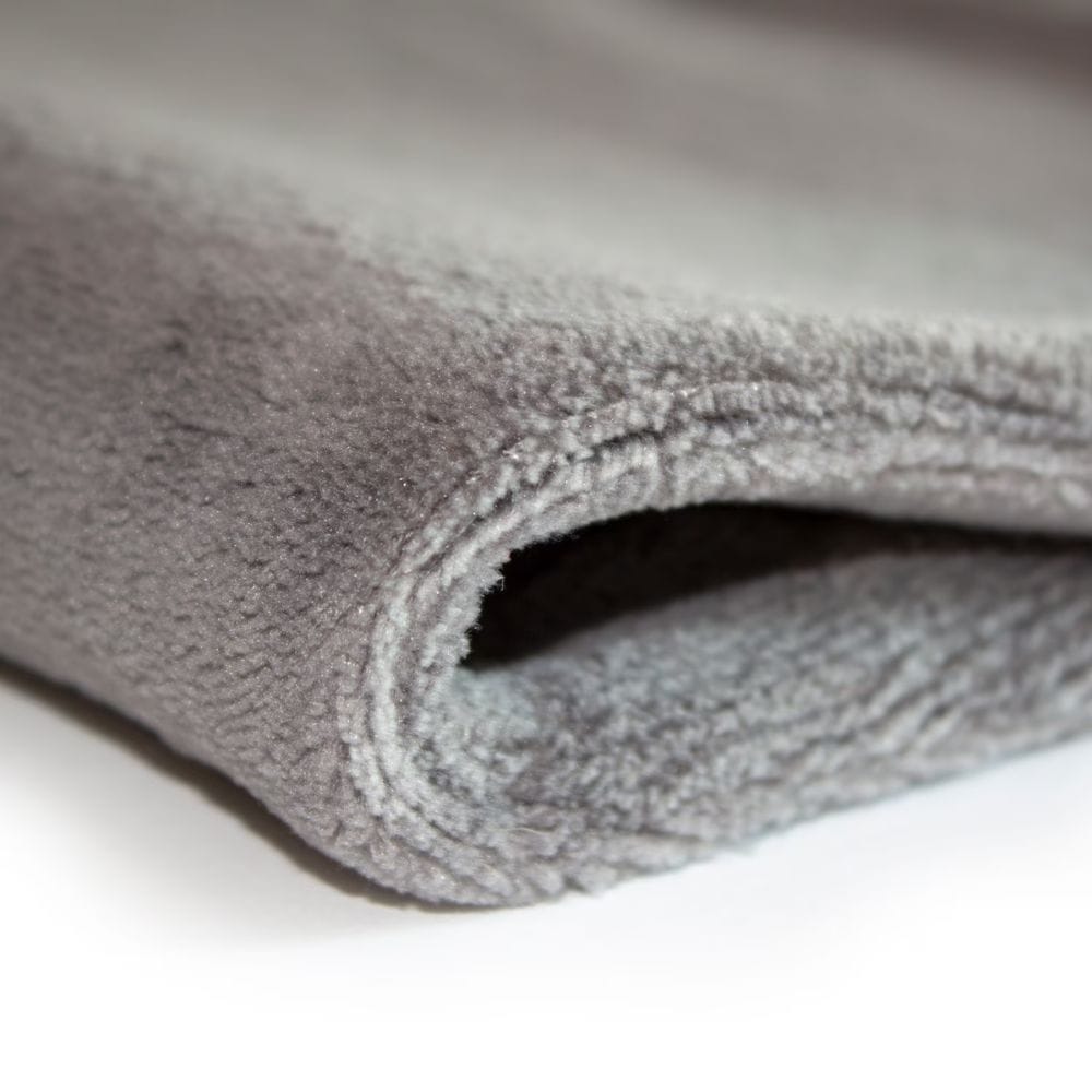 Close-up of a rolled-up gray towel on a white background