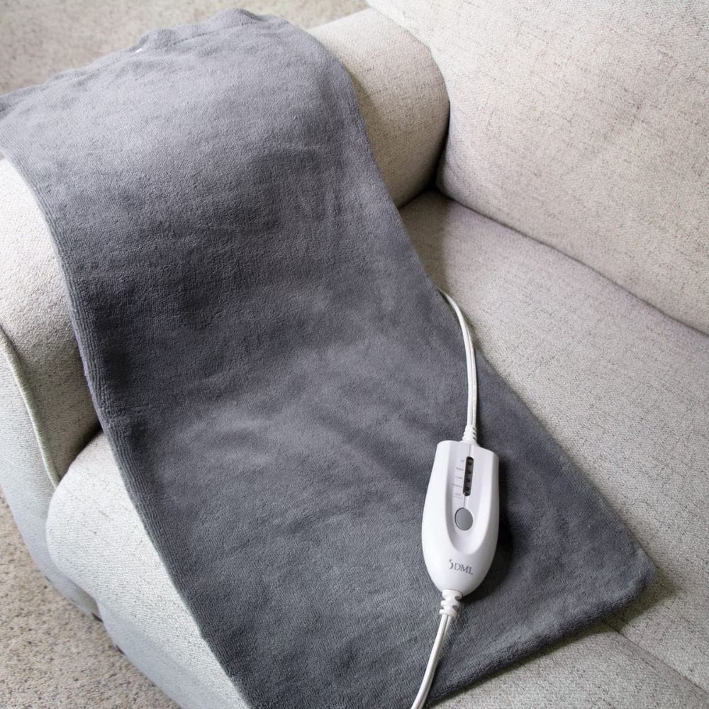 Gray electric blanket with a control panel on a beige couch.