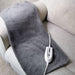 Gray electric blanket with a control panel on a beige couch.