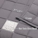 Gray weighted blanket with text labels on non-toxic glass beads and dimensions.