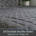 Gray soft breathable microfiber blanket on a bed with text about dimensions and weight.