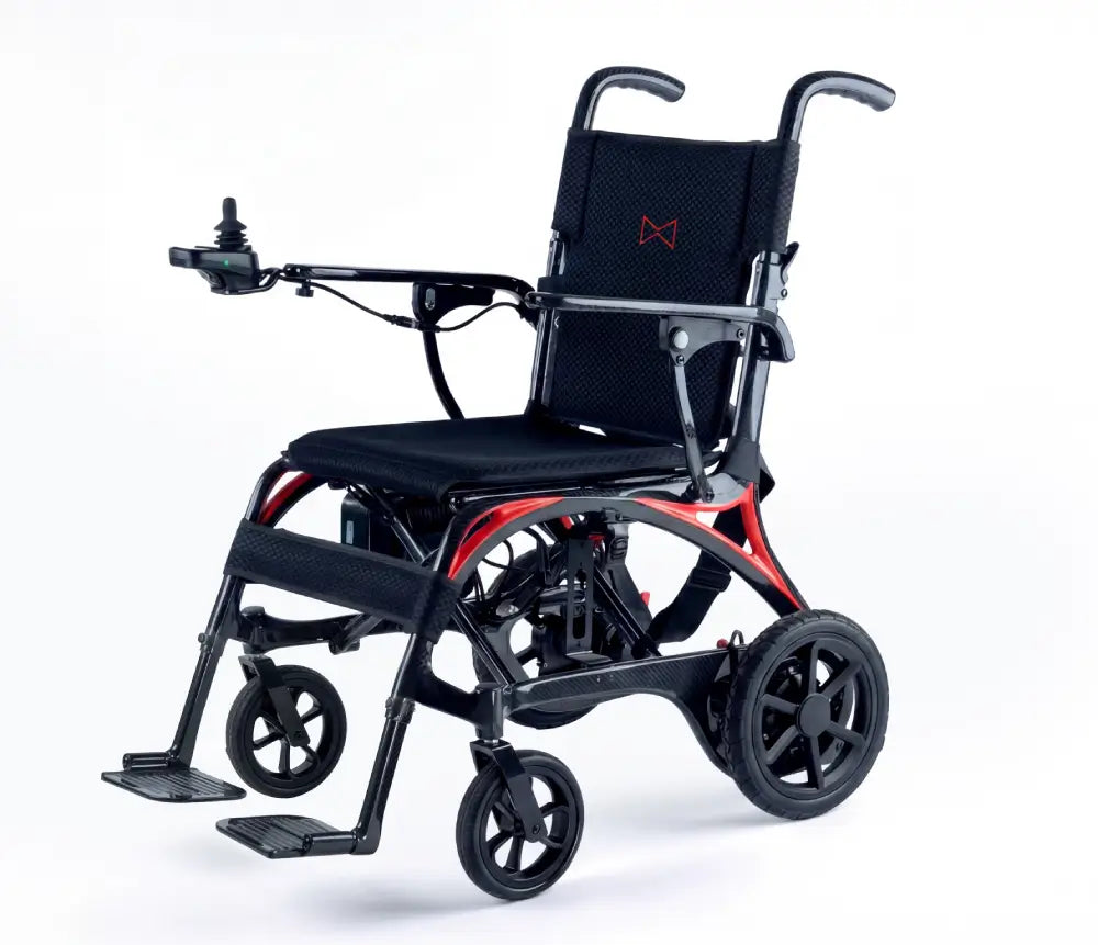 Monarch Mobility Ezi-Fold Carbon power wheelchair with black seating, orange frame accents, joystick control, and swing-away footrests.