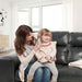 Woman holding a child on a couch in a bright living room