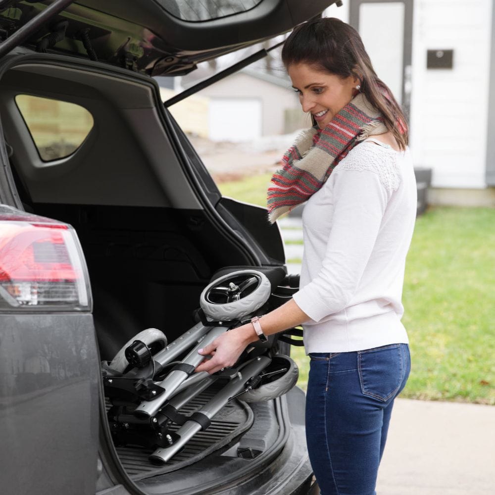 Woman loading a stroller into the back of a car