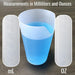 Measuring cup with blue liquid showing measurements in milliliters and ounces on a wooden surface.