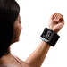 Woman using a blood pressure monitor on her wrist with a white background