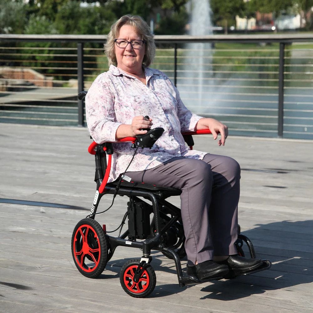 Person using a mobility scooter outdoors on a wooden deck with greenery in the background
