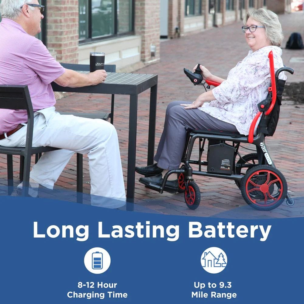 Person using a power wheelchair next to another person at an outdoor table with promotional text about battery life.