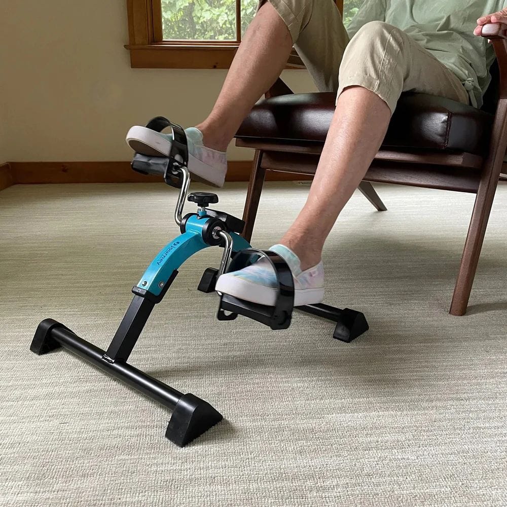 Person using a small exercise bike in a home setting
