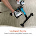 Person using a small exercise bike on a carpeted floor with text about low impact exercise.
