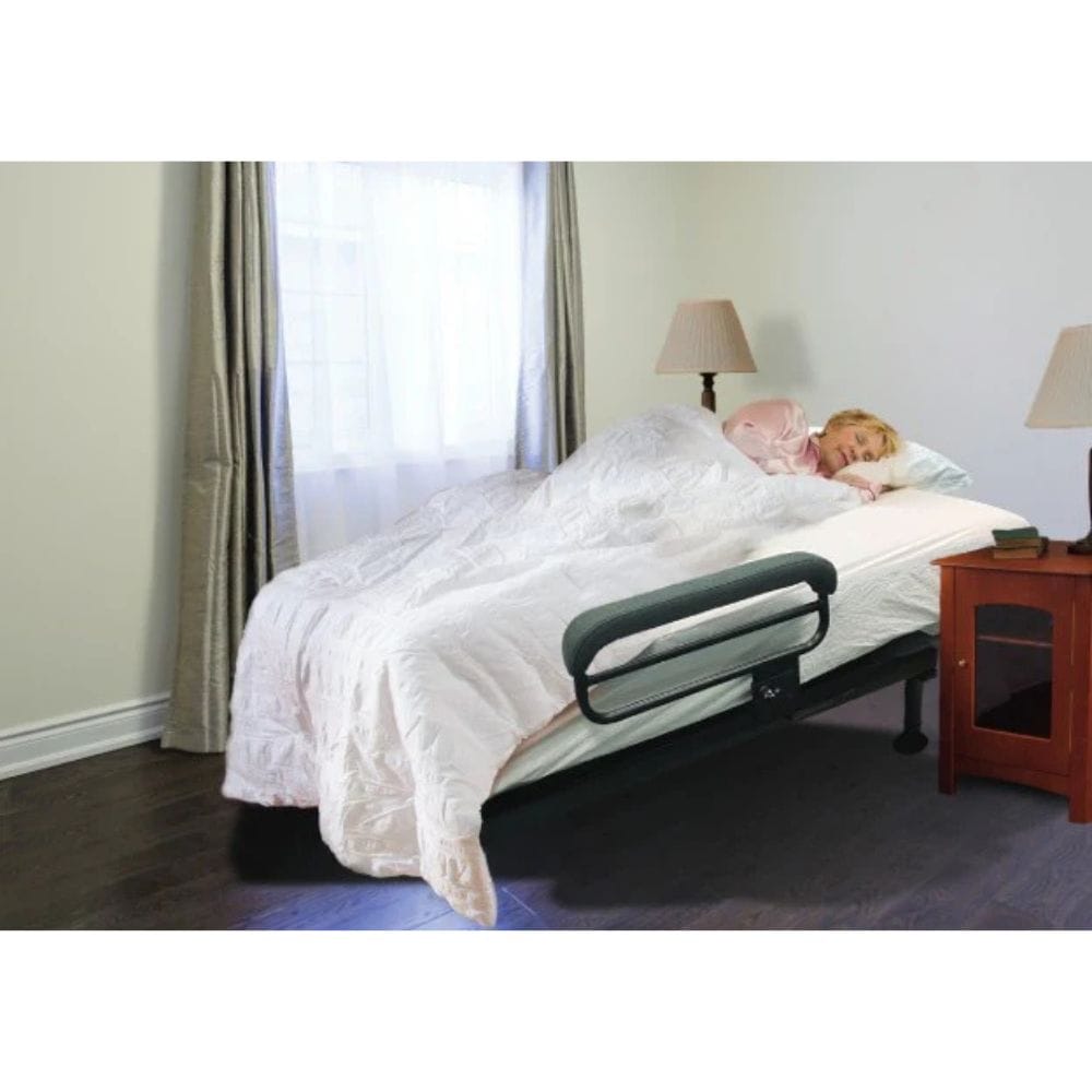 Woman lying on a bed with an adjustable footrest in a bedroom setting.