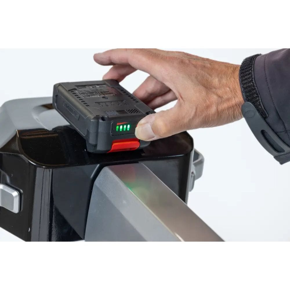 Hand inserting a battery into a power tool with a white background
