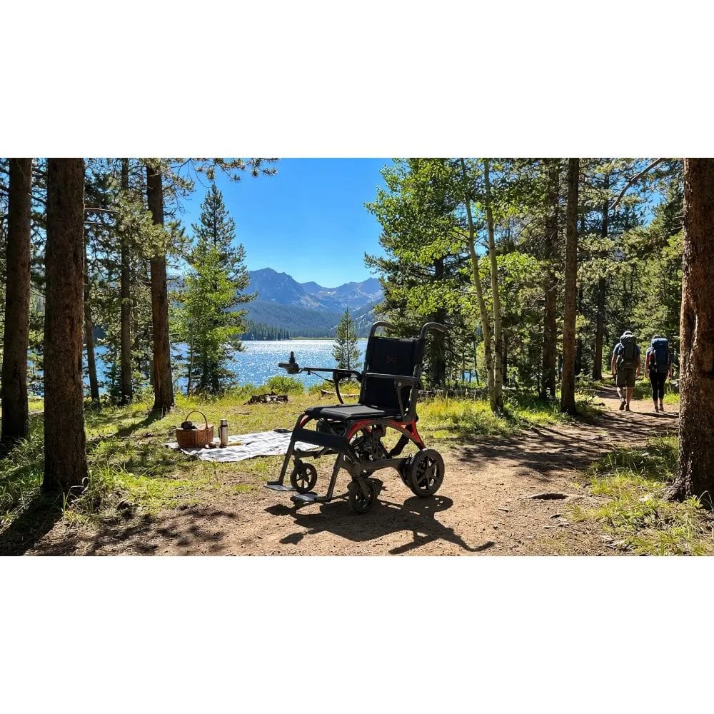 Electric wheelchair on a trail with a scenic view of trees and mountains.
