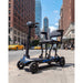 Electric scooter on a city street with tall buildings and a clear sky.