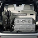 Trunk of a vehicle with suitcases and a bike, labeled 'Packed Small and Light'.