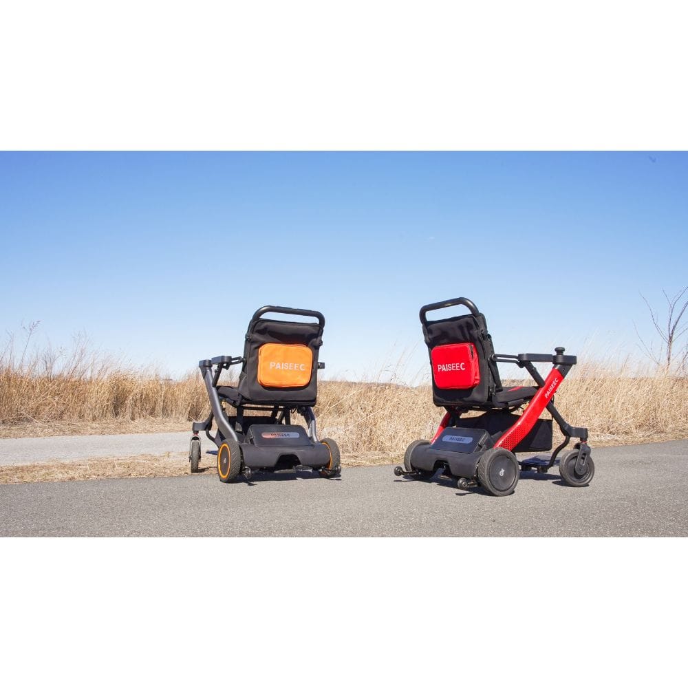 Two mobility scooters on a paved road with a clear blue sky.