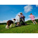 Man in a wheelchair with a dog and a child playing outdoors on a sunny day.