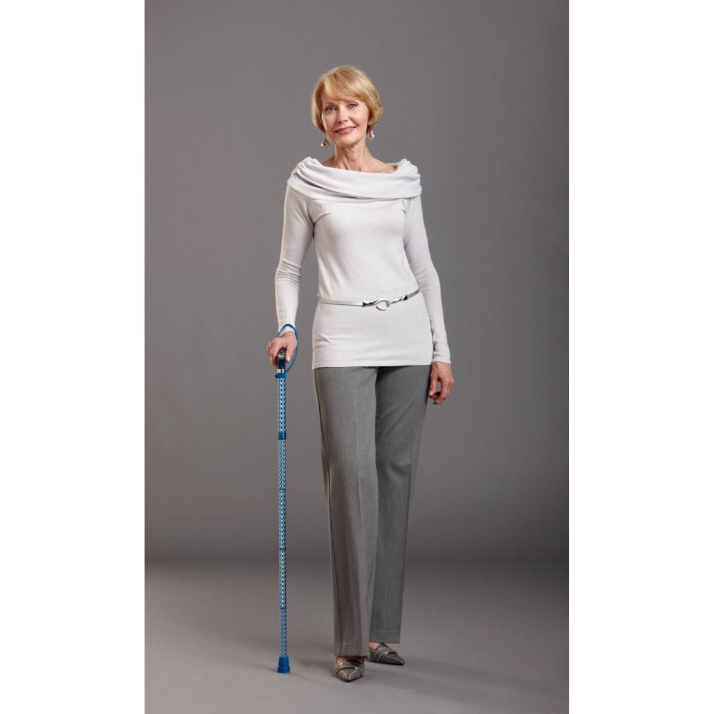 Woman in a light gray outfit holding a blue measuring tape against a gray background