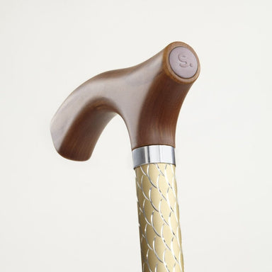 Wooden walking cane with decorative handle and gold shaft on a light background