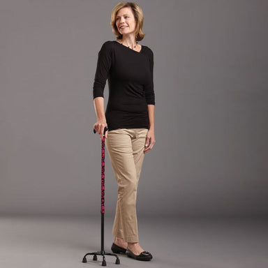 Woman holding a walking cane against a gray background
