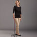 Woman holding a walking cane against a gray background