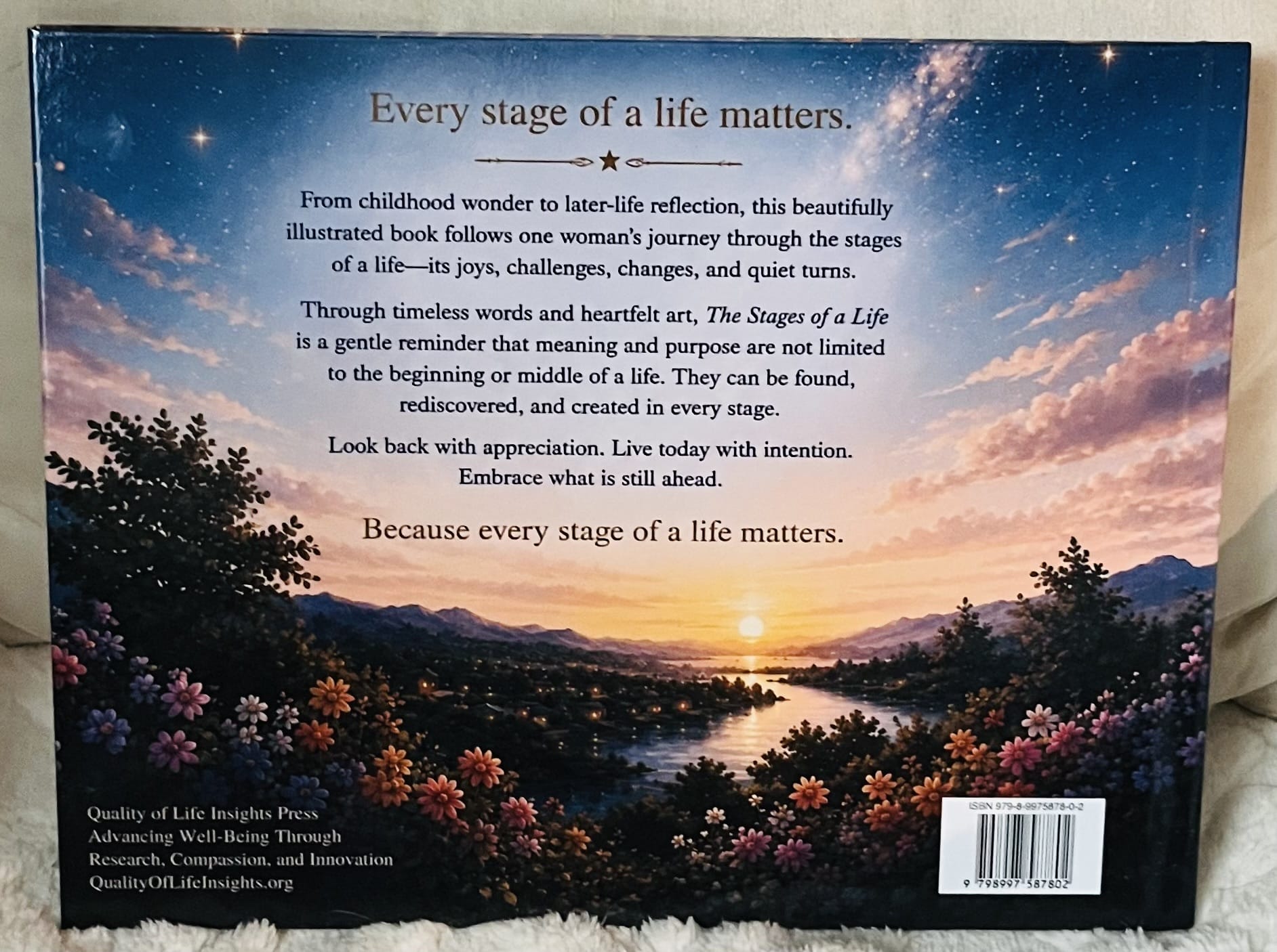The back cover of The Stages of a Life features a tranquil sunset over mountains, water, and wildflowers, along with a message about finding and creating meaning and purpose in every stage of life.