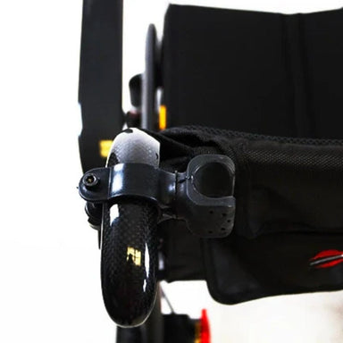 Close-up of a black shoe with a strap attached to a vehicle, possibly a wheelchair.