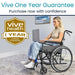 Woman in a wheelchair using a laptop with 'Vive Health' one-year guarantee badge.