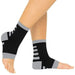 Black and gray ankle support sleeves on a person's legs with a white background