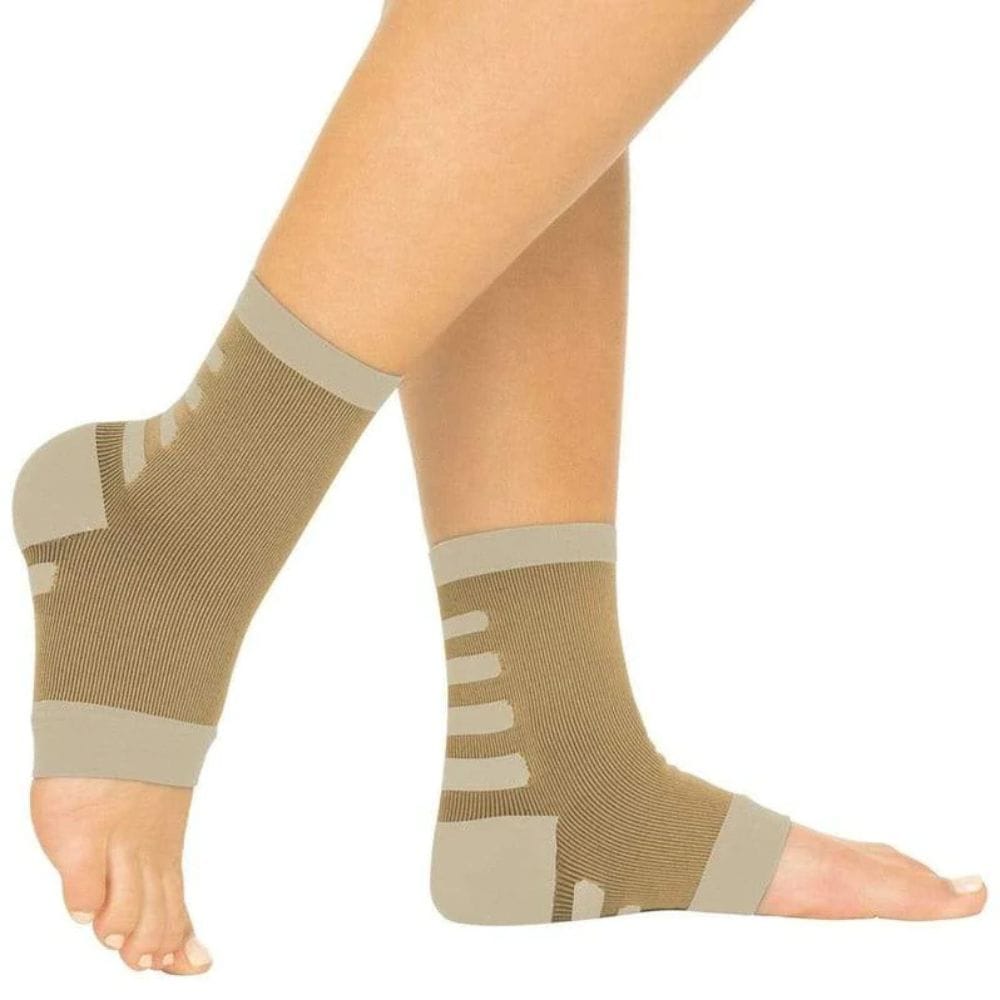 Beige compression socks worn by a person on a white background