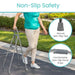 Person using a walking frame with non-slip features on a sidewalk.