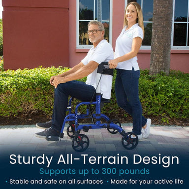 Man using a blue all-terrain walker with a woman assisting him outdoors.