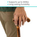 Hand holding a wooden walking stick with text about weight support and durability.