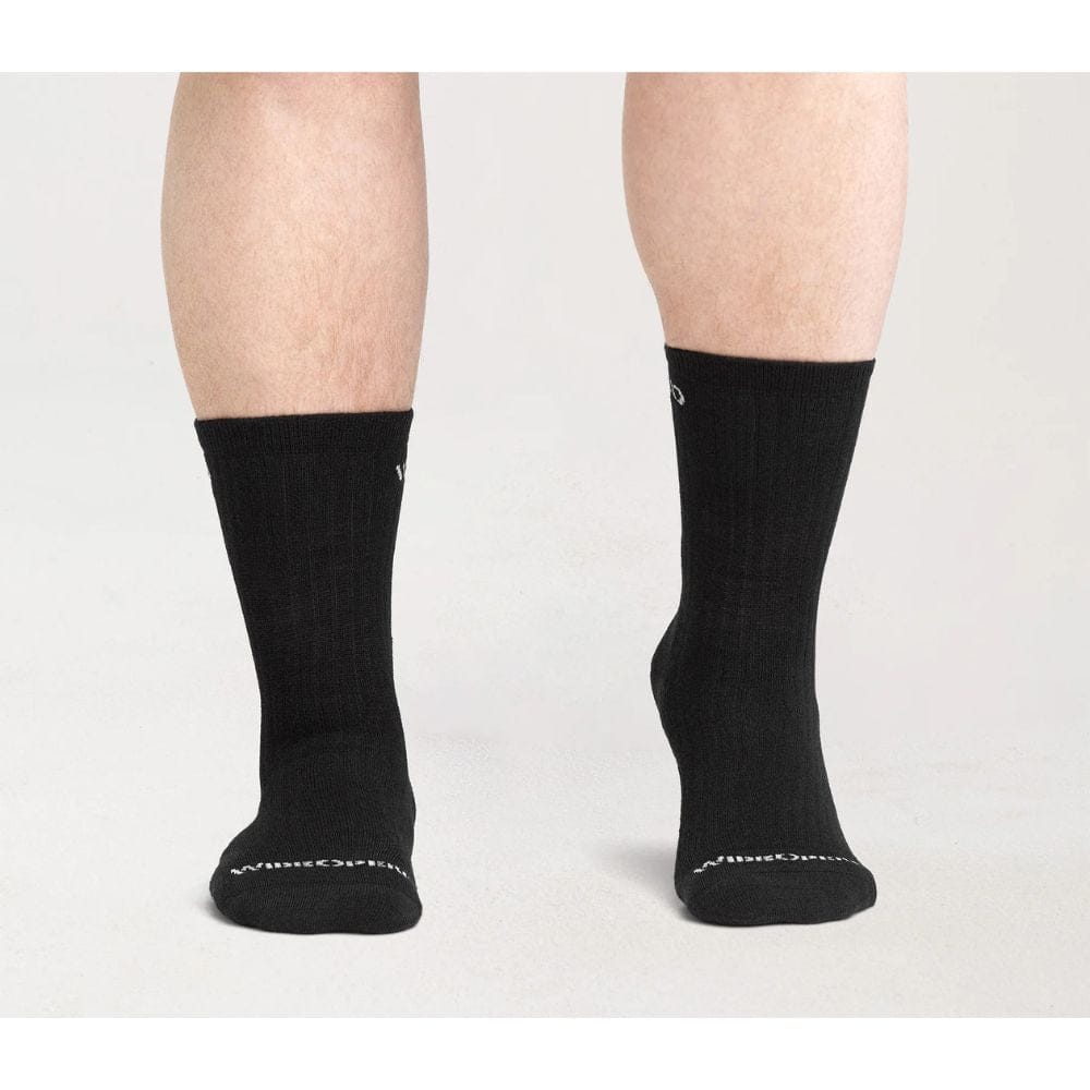 Black socks worn by a person on a light gray background