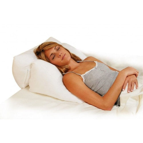 A woman sleeping peacefully on a white contoured pillow on a white bed, wearing a light gray camisole.