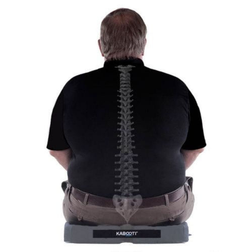 A man seen from behind wearing a black shirt with a printed spine graphic down the back, sitting on a gray Kabbott device against a white background.