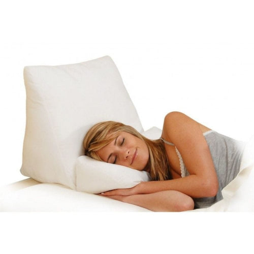 A woman sleeping peacefully on a white bed with a white pillow and a white contoured support pillow under her head.