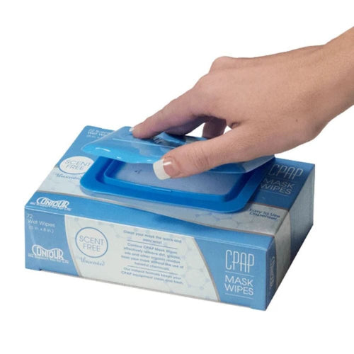 Hand opening a box of CPAP mask wipes with a white background
